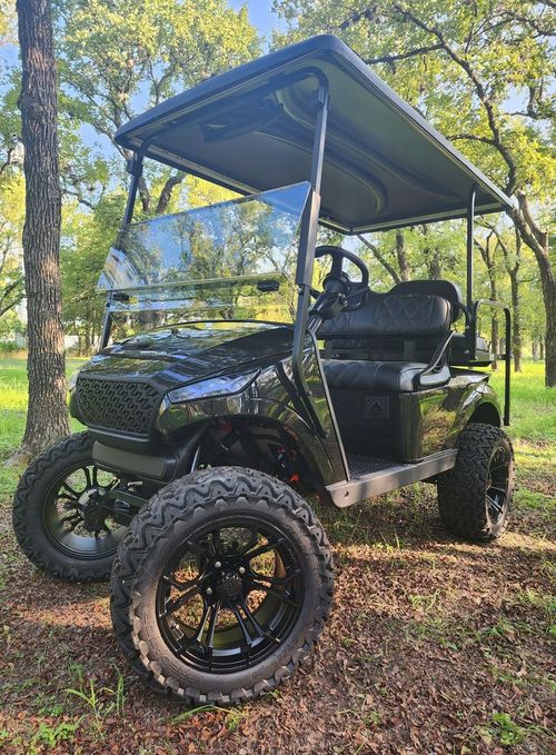 Black custom electric golf cart in an outdoor setting
