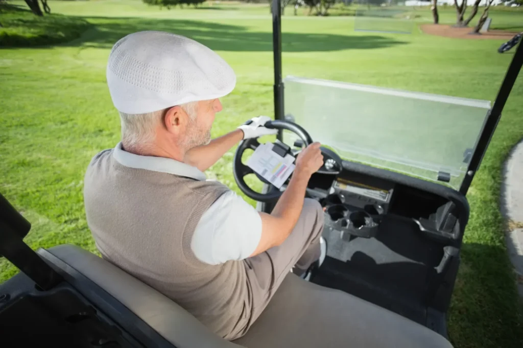 An old man driving a golf cart after charging it successfully