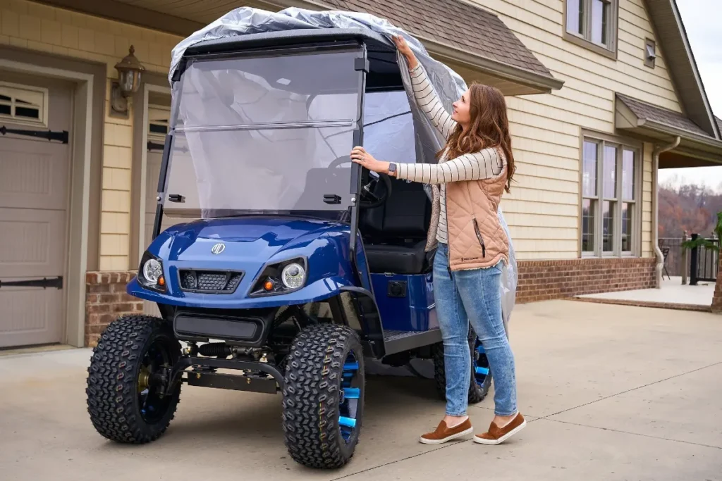 a woman id covering a golf cart with rain cover